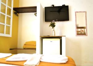 a room with a tv on a wall with towels at Pousada Turquesa By Gente Bonita in Búzios