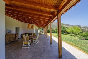 porche con pérgola de madera, mesa y sillas en Luna Bay, en Amarinto