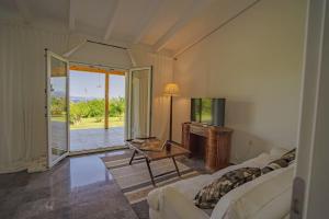 Una sala de estar con un sofá, una mesa y un televisor. en Luna Bay, en Amarinto