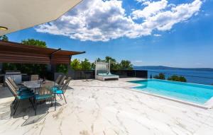 a patio with a table and chairs next to a swimming pool at Villa HB Crikvenica in Crikvenica