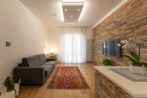 a living room with a couch and a tv on a brick wall at Casa Lo&Ma in Seano