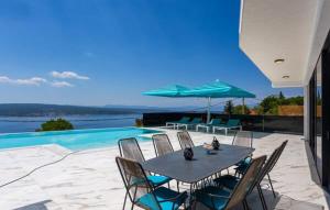 a patio with a table and chairs and a pool at Villa HB Crikvenica in Crikvenica