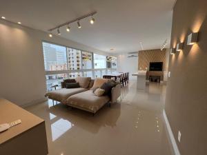 a living room with a couch and a dining room at 3 Suítes com Vista pro Mar em Balneário Camboriú! in Balneário Camboriú