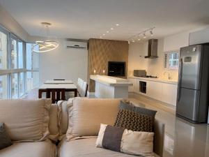 a living room with a couch and a kitchen at 3 Suítes com Vista pro Mar em Balneário Camboriú! in Balneário Camboriú +14 photos