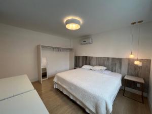 a bedroom with a white bed in a room at 3 Suítes com Vista pro Mar em Balneário Camboriú! in Balneário Camboriú