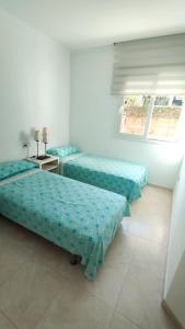 a room with two beds and a window at Apartamento Familiar Jávea en Planta Baja in Jávea