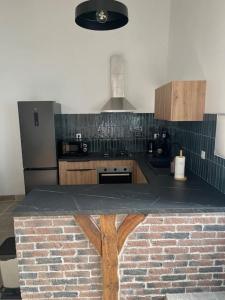 a kitchen with a brick counter top in a kitchen at L'atelier gîte classé 3 étoiles in Aigrefeuille-dʼAunis