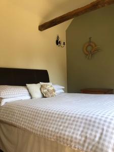 a bedroom with a large bed with white sheets at Oak Barn in Wigginton