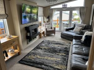 un soggiorno con un divano e una TV di Edinburgh Lodge-Sleeps 6-Pet Friendly-Beach&Views a Prestonpans