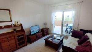 a living room with a couch and a tv at Apartamento Familiar Jávea en Planta Baja in Jávea