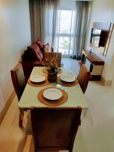 a dining room table with two plates and a couch at 1205 AP 2 4 Com Suíte em Barreiras in Barreiras +7 photos