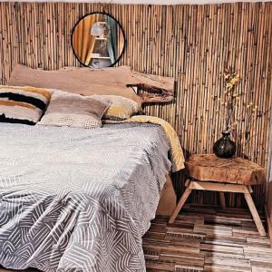 a bedroom with a bed and a table and a mirror at Petite Gîte Atypique chez sam est gael in Charix