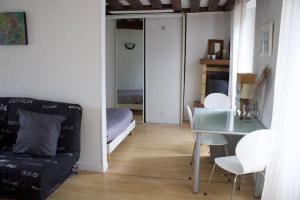 ein Wohnzimmer mit einem Glastisch und einem Bett in der Unterkunft Charmant Vintage Chaville in Chaville