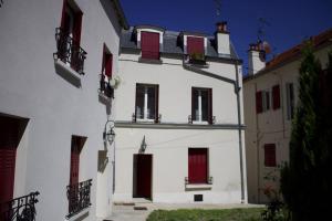 ein weißes Gebäude mit roten Türen und Fenstern in der Unterkunft Charmant Vintage Chaville in Chaville