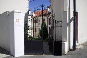 ein schwarzes Tor zu einem weißen Gebäude mit einem Haus in der Unterkunft Charmant Vintage Chaville in Chaville + 4 Fotos