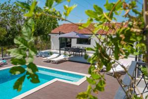 a villa with a swimming pool and a house at Villa Florinda with Pool and Prime Location near Split in Srinjine