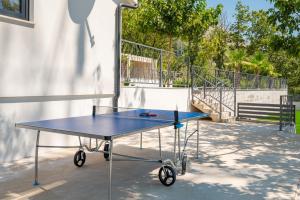 a blue ping pong table in front of a building at Villa Florinda with Pool and Prime Location near Split in Srinjine