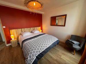 a bedroom with a bed and a chair and a mirror at Appartement Gordon Smith en plein centre - 2 personnes in Sainte-Mère-Église