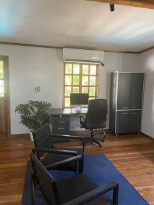 an office with chairs and a desk and a refrigerator at Hermoso Apartamento con Piscina in Nicoya