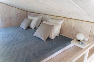 a room with a bed with pillows and a table at Forrest Guest House Ameli in Ķesterciems