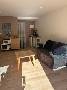 a living room with a couch and a coffee table at Studio au cœur du vieux village in Vitrolles