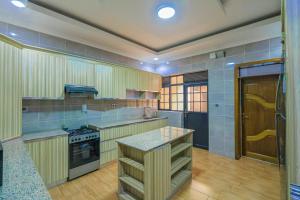 a large kitchen with a stove and a counter at Lux Holidays Villa in Kigali
