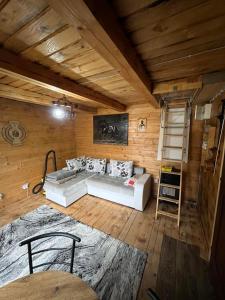 a living room with a white couch in a wooden room at Vikendica Davidović in Berane