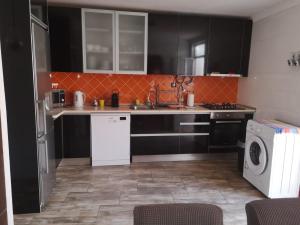 a kitchen with black cabinets and a washer and dryer at Casa 33 in Lagos +6 photos