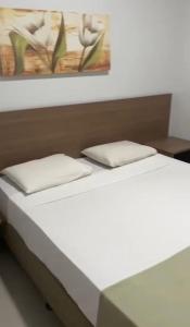 a bed with two pillows on top of it at Marina Flat & Náutica in Caldas Novas +20 photos