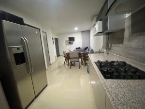 a kitchen with a stove and a dining room at Beautiful Family Beach House Nuevo Vallarta in Naranjo