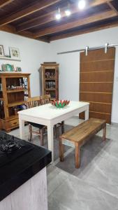 a white table and a bench in a room at Apto Duplex com Mezanino in Juquei