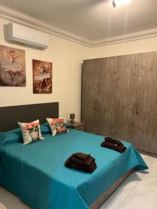 a bedroom with a blue bed with two towels on it at Bella Qawra Maisonette in St. Paul's Bay