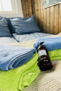 a bottle of oil sitting on a bed with towels at Badehuset, Harmoni, med privat strand in Hemnes