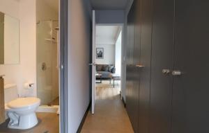 a bathroom with a toilet and a hallway at Living 110 Suites by Wynwood House in Lima