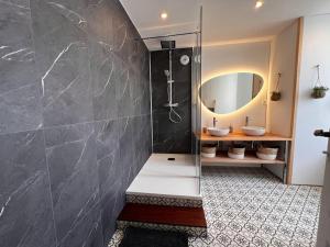 a bathroom with two sinks and a shower with a mirror at Maison pour 10 personnes max en plein centre de Ste Mère Eglise in Sainte-Mère-Église