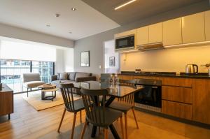 a kitchen and living room with a table and chairs at Living 110 Suites by Wynwood House in Lima