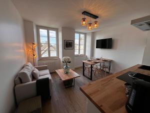 a living room with a couch and a table at Maison pour 10 personnes max en plein centre de Ste Mère Eglise in Sainte-Mère-Église