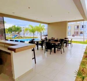 a restaurant with tables and chairs and a pool at Ela in Playa del Carmen