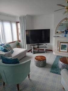 a living room with a couch and a tv at Willow Lodge , Corskie Drive Macduff-Banff in Macduff