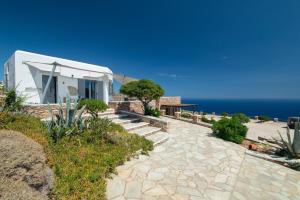 a stone walkway leading to a house with the ocean at Windmill Bella Vista in Artemonas