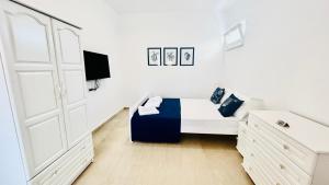 a white bedroom with a bed and a tv at Mirem Boutique Apartments, Central Apartments in Ofrínion