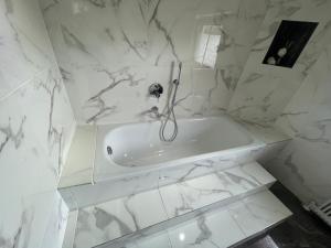 a white marble bathroom with a tub in it at Charmante Ferienwohnung im Herzen Tirols in Hatting +38 photos