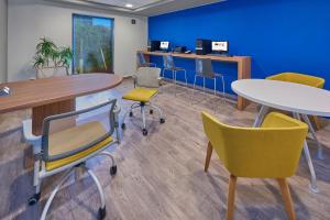 ein Büro mit Tischen und Stühlen und einer blauen Wand in der Unterkunft City Express by Marriott Saltillo Norte in Saltillo