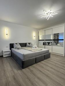 a bedroom with a large bed and a chandelier at Karlsburg Apartament in Alba Iulia