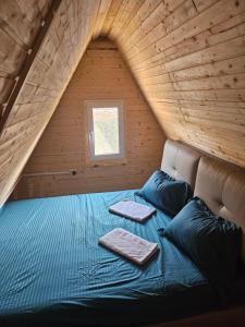 un lit avec deux oreillers dessus dans une chambre dans l'établissement Cabană la LERI, à Icloda