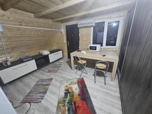 Cette chambre comprend un bureau, une table et des chaises. dans l'établissement Cabană la LERI, à Icloda
