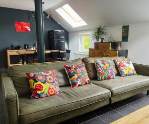 a brown couch with pillows on it in a living room at Peace&Loft in Durbuy Old in Durbuy