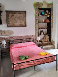a bedroom with a bed with a pink blanket at Casa vacanze Costa Verde, Guspini, Sardegna in Guspini