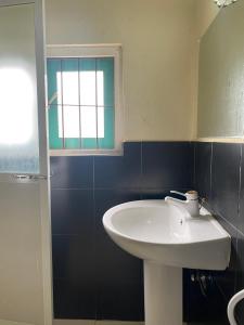 a bathroom with a white sink and a window at NimSri Villa by Prazzventures in Mirissa