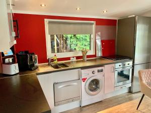a kitchen with a washing machine and a sink at Aschenputtel Relax Bernsteinsee Stüde in Sassenburg